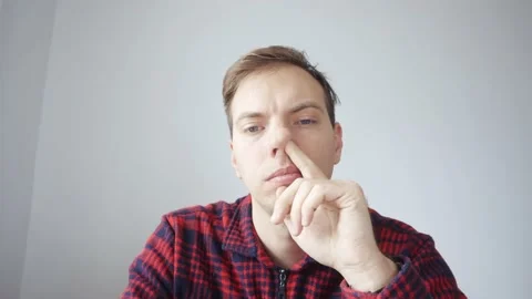 A young man picks his nose in front of a... | Stock Video