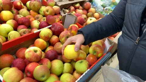 Young man picks red-yellow apples in a plastic bag Video stock 120323982