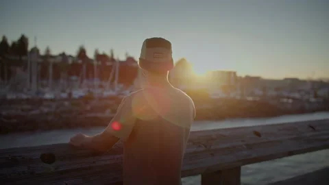 Young man on pier looking at beautiful sunset views 库存影片 220301787
