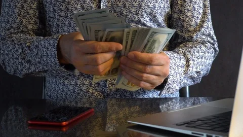 A young man piles a stack of dollars. Stock Footage 114380012