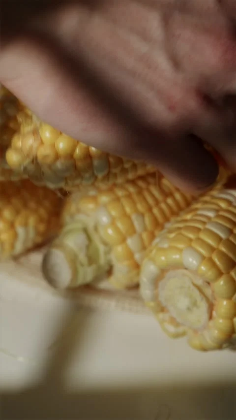 Young man placing fresh corn cobs into linen shopper bag 스톡 동영상 343403469