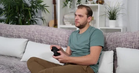 Young Man Play and Loosing a Games a Disappointed Activity on Living Room Sofa Stock Footage 83428558
