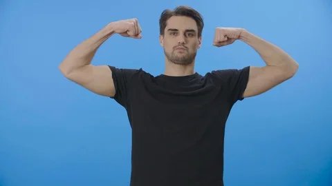 Young man playfully showing off his strength 4K Stock Footage 88399863