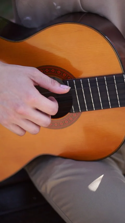 Young man is playing acoustic guitar outside Stock Footage 283576748
