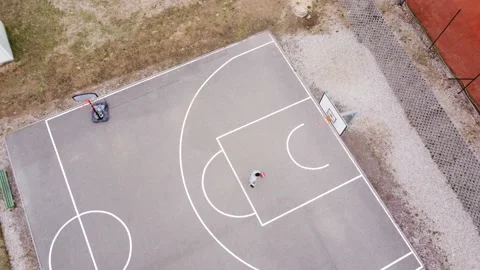 Young man playing basketball and making shots alone Stock Footage