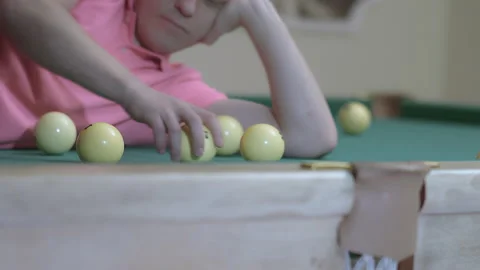 Young man playing with billiard balls while lying on billiard table Stock Footage 160236702
