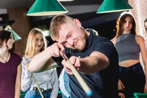 Young man playing in billiard. Posing near the table with a cue in his hands Stock Illustration