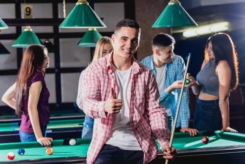 Young man playing in billiard. Posing near the table with a cue in his hands Stock Illustration