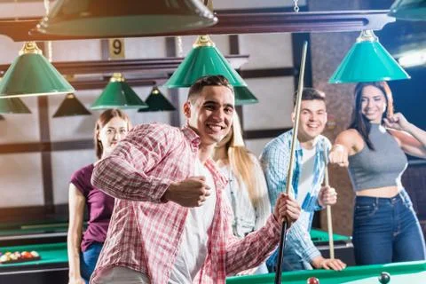 Young man playing in billiard. Posing near the table with a cue in his hands Stock Illustration
