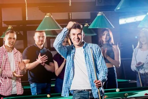 Young man playing in billiard. Posing near the table with a cue in his hands Stock Illustration