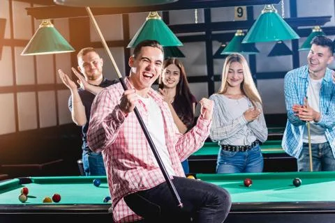 Young man playing in billiard. Posing near the table with a cue in his hands Stock Illustration