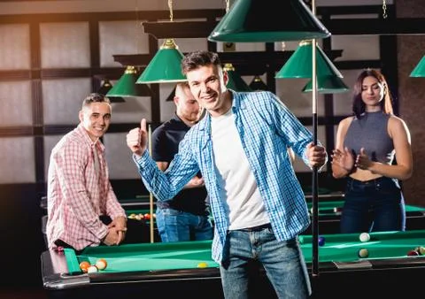 Young man playing in billiard. Posing near the table with a cue in his hands Stock Photos