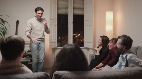 Young man playing charades with some friends at home Stock Footage 46494070