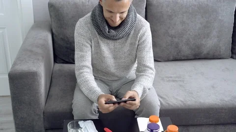Young man playing a computer game on a smartphone during illness at home Stock Footage 112645891