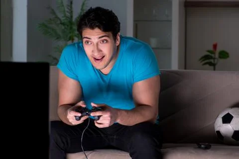 Young man playing computer games late at night Foto stock