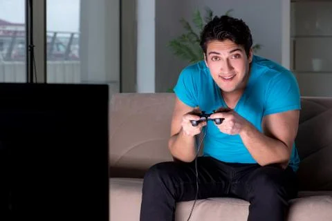 Young man playing computer games late at night Foto stock