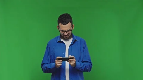 Young man playing game with his smart phone. Chroma Key background. Video stock 168235801
