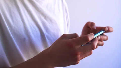 Young man playing a game with his smart phone ( mobile phone) held horizontally Stock Footage 273833114