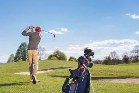 Young man playing golf on course. Stock Photos