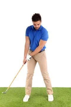 Young man playing golf on course against white background Photos