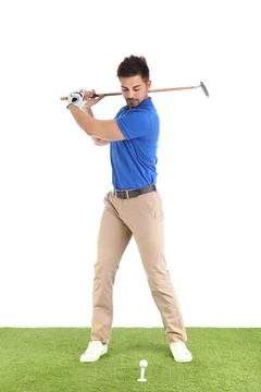 Young man playing golf on course against white background Photos