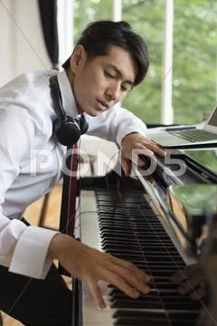 Young Man Playing On A Grand Piano In A Rehearsal Studio.