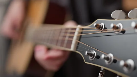 Young man is playing a guitar. close up of string and fingers 動画素材 301307843
