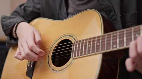 Young man is playing a guitar. close up of string and fingers. 動画素材 301308045