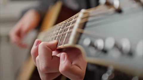 Young man is playing a guitar. close up of string and fingers Stock Footage 301308950