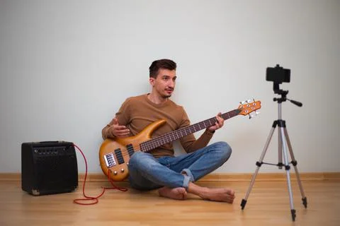 Young man playing on a guitar in front of the camera Stock Photos