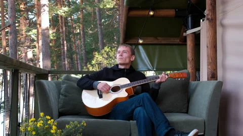 Young Man Playing Guitar Outside Glamping Tent Stock Footage 139401968