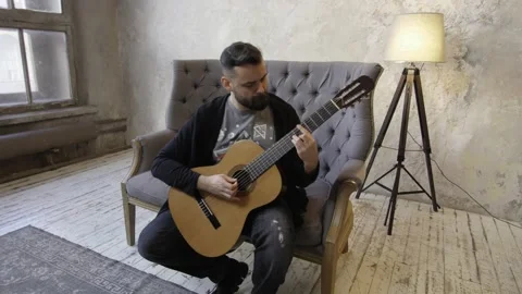Young man playing guitar in the room Stock Footage 139763571