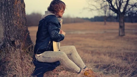 Young man playing guitar at sunset 動画素材 88975175