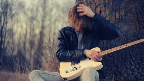 Young man playing guitar at sunset Stock Footage 90773476