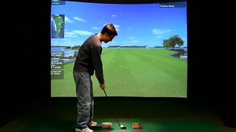 Young man playing indoor golf simulation game Stock Footage 1034488