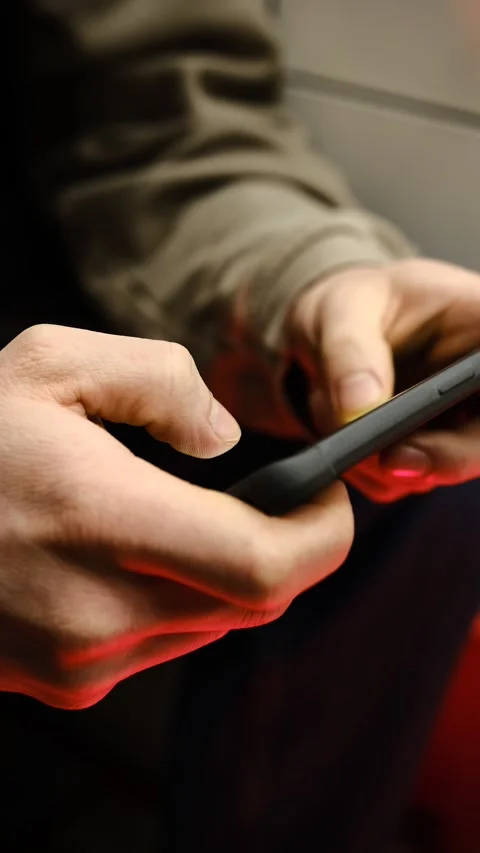 Young man playing mobile game with fast finger movements and colorful pulsating  Stock Footage 300294070