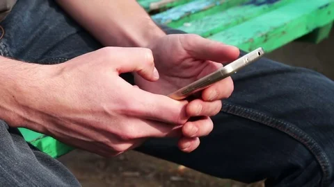 Young man Playing on mobile phone, looking at screen Stock Footage