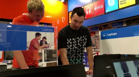 Young man playing new computer inside store Stock Footage 65771484