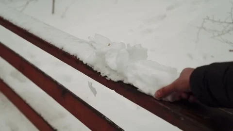 A young man playing with snow in winter forest. It makes snowballs and throwing Stock Footage 73669765