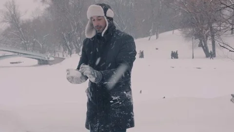 Young man playing snowballs in the park Video stock 72099345