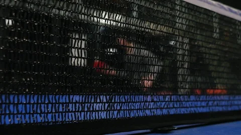 Young man playing table tennis . Black net on foreground in focus Видео 103281735