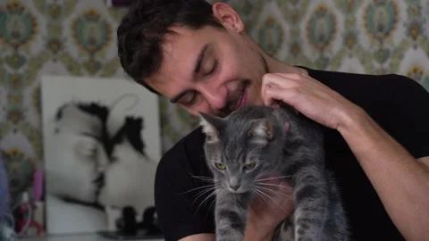 Young man is playing with their cat on the bed. Stock Footage 229653571