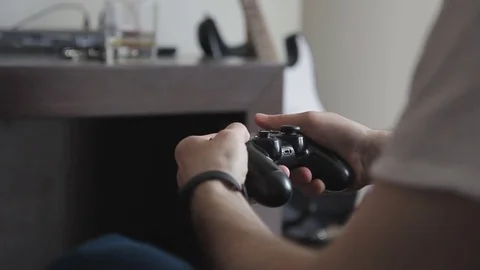Young man is playing using game console sitting on sofa at home. Stock Footage 83027701