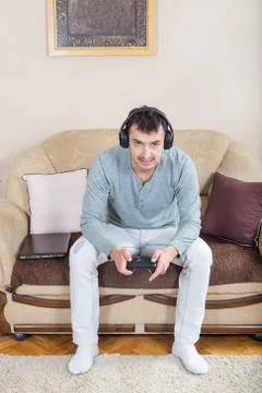 Young man playing video games with wireless Bluetooth joystick Stock Photos