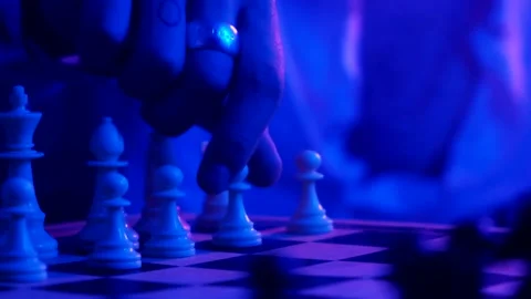A young man plays chess with a blue background Stock Footage 139499438