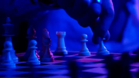 A young man plays chess with a blue background Stock Footage 139499453