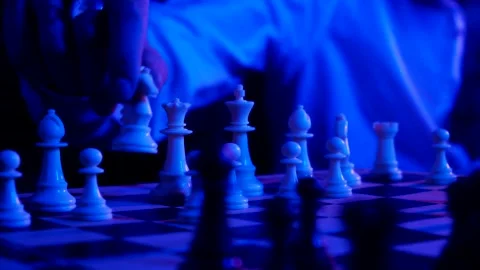 A young man plays chess with a blue background Stock Footage 139499461