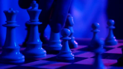 A young man plays chess with a blue background Stock Footage 139499465