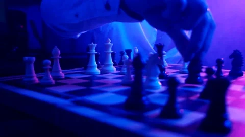 A young man plays chess with a blue background Stock Footage 139499482