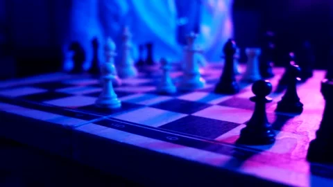 A young man plays chess with a blue background 스톡 동영상 139499489